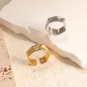 Detail of irregular geometric open rings with hammered texture in gold and silver
