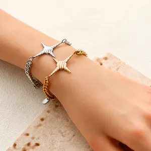 Detail von gold- und silberfarbenen Sternenarmbändern am Handgelenk mit Markenanhängern