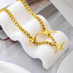 Detailaufnahme einer goldenen Panzerkette mit Anhängern im Stacheldraht Stern-Design