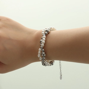 Elegante bracciale a doppio strato con perle bianche e sfere d'argento sul polso