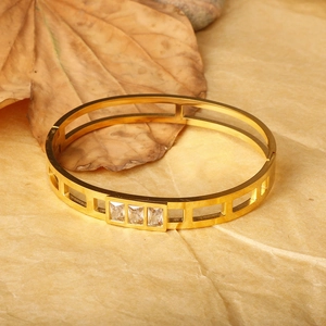 Minimalist gold plated titanium steel bangle featuring hollow geometric design and clear zircons