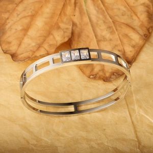 Detail of hollow out titanium steel bracelet with three rectangular zircon inlays
