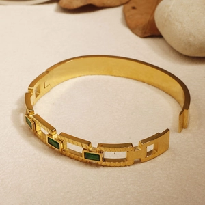 Detail of 18k gold stainless steel bracelet with green emerald square zircon stones