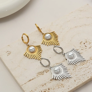 Detailed view of sunburst fan earrings with centered pearl inlay in gold and silver