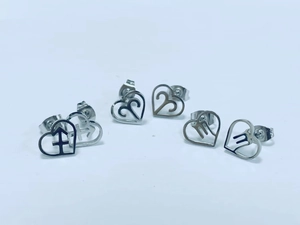 Detailed macro view of heart-shaped stainless steel zodiac earrings with butterfly backs