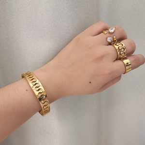 Gold stainless steel set with teardrop zircon rings and a wavy diamond open bangle