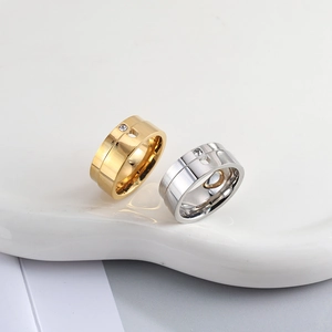 Detail of gold and silver stainless steel rings with heart cutout and zircon inlay