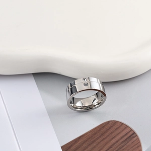 Macro shot of silver teardrop diamond ring with wide polished stainless steel band