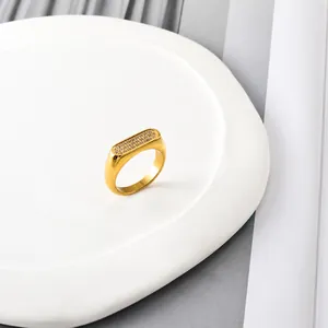 Makroansicht des vergoldeten rechteckigen Rings mit Pavé-Fassung aus Zirkoniasteinen