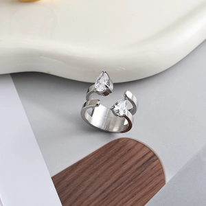 Macro detail of silver bypass ring featuring pear-cut zircon stones and matte finish