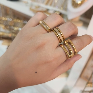 Dreiteiliges vergoldetes Ring-Set mit Pavé-Kristallen, am Finger in einem Juweliergeschäft