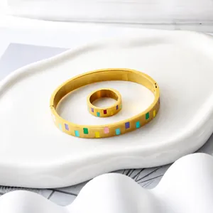 Detail eines 18K vergoldeten Schmucksets mit bunten Emaille-Blöcken auf einem weißen Tablett