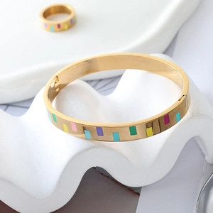 Detail eines 18K vergoldeten Edelstahlarmbands und Rings mit buntem Emaille-Inlay
