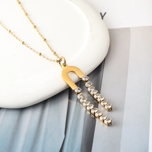 Detail of gold U-shaped pendant necklace with double rows of sparkling cubic zirconia