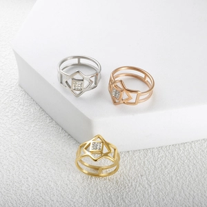 Dettaglio di anelli geometrici traforati in oro, oro rosa e argento con cristalli quadrati
