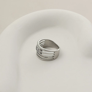 Detail van zilveren opengewerkte vierlaagse ring met een vierkante glanzende edelsteen