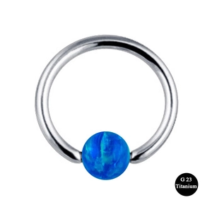 Macro detail of G23 titanium body piercing ring with a vibrant blue opal bead insert