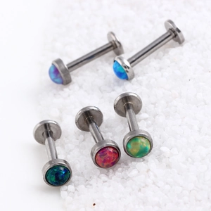 Set mit fünf Labret-Steckern aus Chirurgenstahl mit bunten Opalsteinen auf weißem Sand