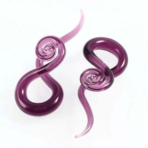 Dettaglio macro dei dilatatori a spirale in vetro viola con finitura traslucida e levigata