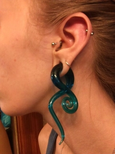 Dettaglio di un dilatatore per orecchie a spirale in vetro verde acqua per piercing