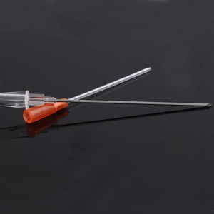Detail of single-use stainless steel piercing needle with orange plastic hub and catheter