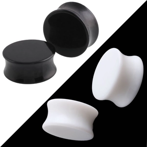 Detailopname van zwart-witte acryl oorpluggen met dubbel gewelfde ergonomische vorm