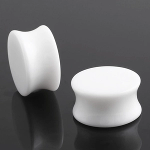 Macro-opname van witte acryl oordoppen met dubbel uitlopend ontwerp en matte glans
