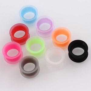 Macro view of flexible silicone double-flared flesh tunnels in nine assorted colors