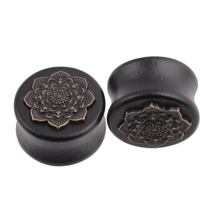 Macro detail of wooden ear gauges with bronze mandala flower pattern in vintage style