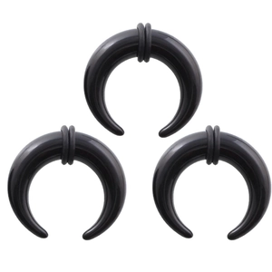 Macro shot of black acrylic snail ear tapers with rubber O-rings on a white background