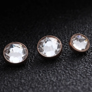 Three G23 titanium rose gold dermal anchors with clear faceted crystals for body piercing