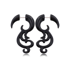 Détail des boucles d'oreilles en acrylique noir de style tribal avec design symétrique
