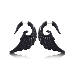 Détail des boucles d'oreilles noires en acrylique avec design en spirale sur fond blanc brillant