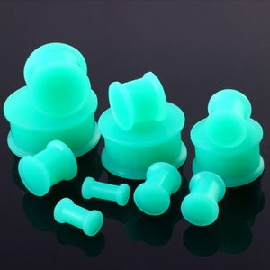 Neon groene doorschijnende siliconen ear plugs in diverse maten op zwart