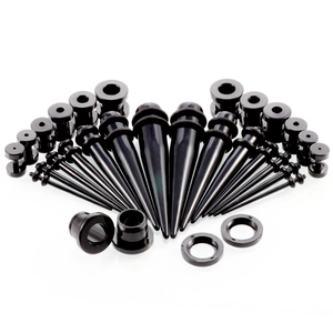 Macro-opname van de zwarte acryl oorpiercing stretchset met verschillende maten tapers en tunnels