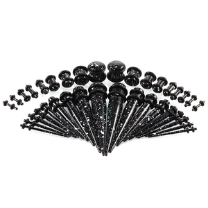 Ohr-Stretching-Set aus Acryl mit schwarz-weiß gesprenkelten Dehnern und Plugs