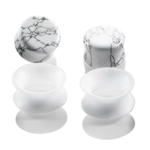 Macro detail of marble-patterned stone and translucent silicone double flare ear plugs