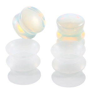 Detail of white opal stone ear plugs and translucent silicone tunnels on white background
