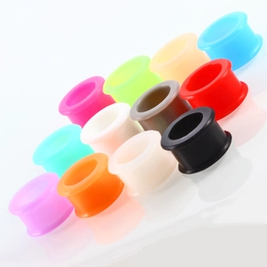 Collection of colorful silicone flesh tunnels in various vibrant shades on white surface