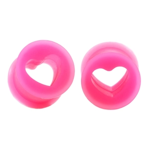 Macro view of bright pink heart-shaped silicone ear tunnels and stretchers for body piercing