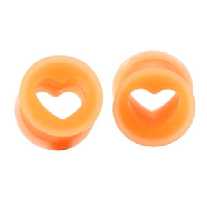 Macro view of orange heart-shaped hollow silicone ear tunnels with matte texture finish
