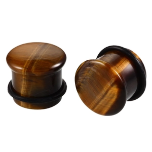 Detailed view of tiger eye stone ear gauges with black rubber O-rings and cat eye effect