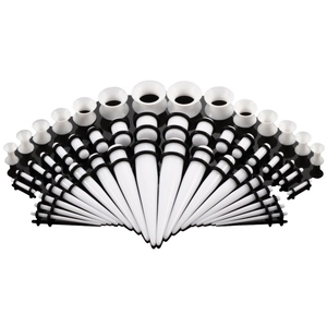 Detailliertes Set weißer Acryl-Ohrdehner und Plugs mit schwarzen O-Ringen aus Gummi auf Weiß