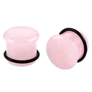 Macro detail of pink translucent stone mushroom ear plugs with black O-ring fasteners