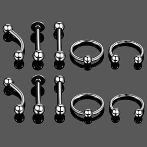 Macro detail of 10-piece stainless steel body piercing set with mirror reflections