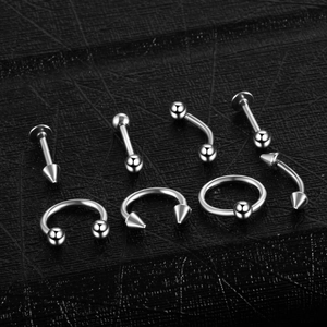 Gros plan sur un kit de piercings en acier inoxydable avec barres et anneaux argentés