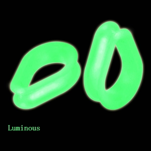 Luminous green silicone teardrop ear tunnels showing vibrant neon glow on black background