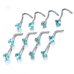 Detail of 12-piece nose stud set with heart and round blue zircons on silver metal posts