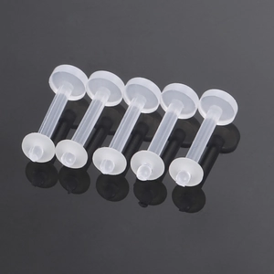 Close-up of 5-piece set of transparent bioflex flexible labret studs on a black surface