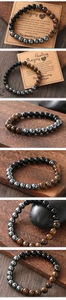 Detail of tiger eye, hematite, and obsidian beads on a stretch bracelet set on wood